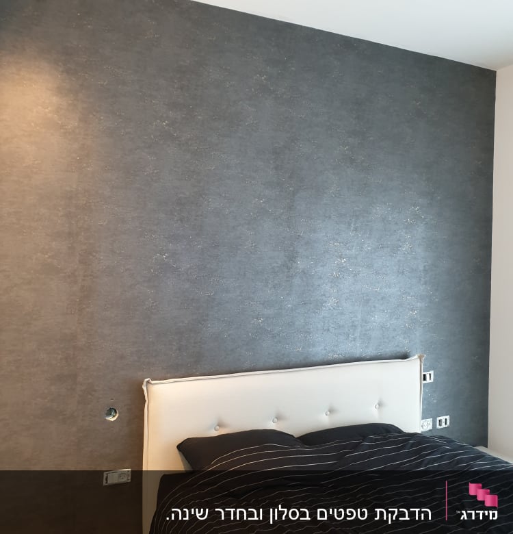 קיר עם טפט כהה ומנורת תקרה